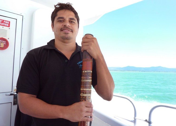 This photo taken on September 18, 2014 shows Aboriginal Australian Gavin Singleton standing with his digderidoo on a boat traveling to the Great Barrier Reef. Glenda Kwek/AFP
