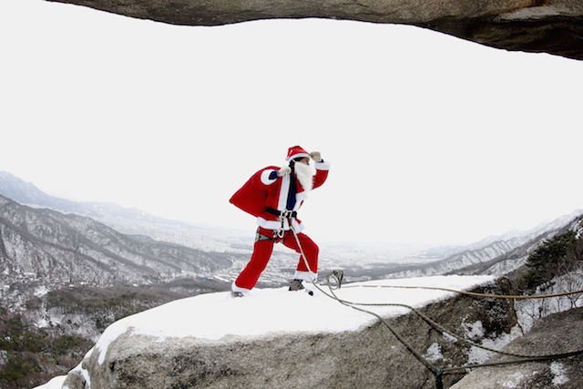 Kapten Kepala Badan SAR Gunung Korea Selatan Kim Chang-Gon menggunakan kostum Santa Claus saat mendaki Gunung Buckhan dekat Seoul, Korea Selatan, 21 Desember 2014. Foto oleh Jeon Heon-Kyun/EPA 