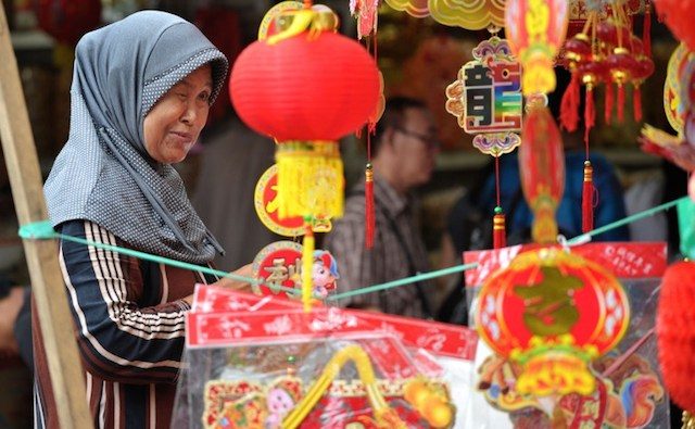 Seorang wanita di sebuah toko perhiasan Imlek. Foto oleh Bay Ismoyo/AFP 