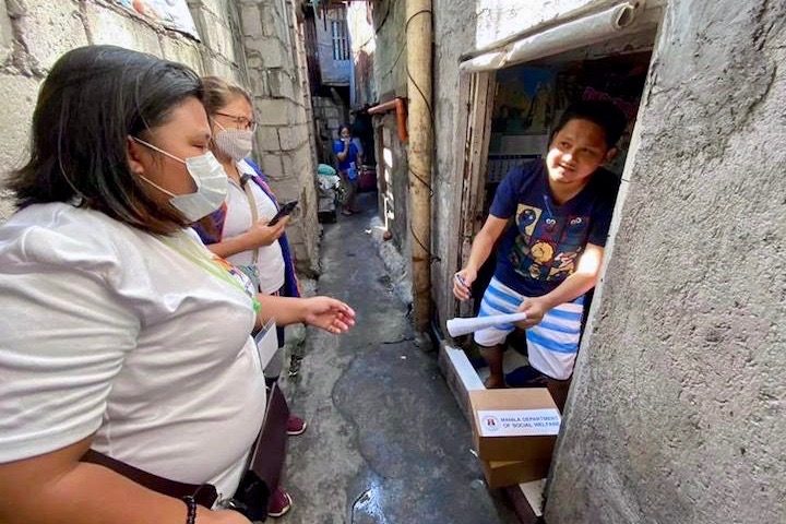 RELIEF WORK. Manila government personnel distribute food packs for the indigent and disenfranchised families. Photo from Moreno's Facebook page  