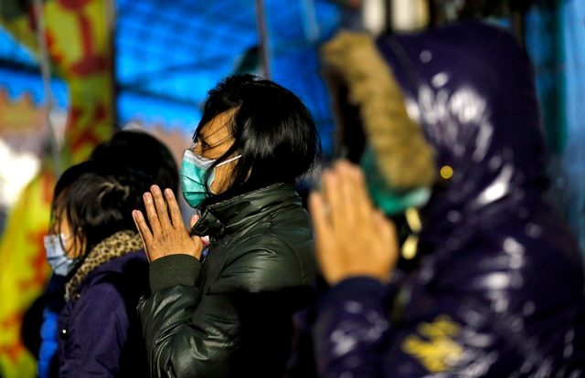 Korban selamat berdoa ketika tim SAR terus melanjutkan pencarian korban lainnya di reruntuhan gedung di kota Tainan, Taiwan. Foto oleh Ritchie B. Tongo/EPA 