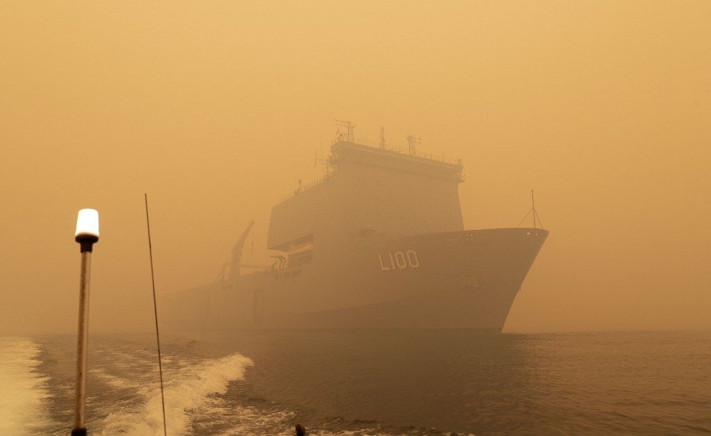 SEABORNE EVACUATION. This handout photo taken on January 2, 2020 and released by the Royal Australian Navy shows HMAS Choules sailing off the coast of Mallacoota, Victoria state to assist in bushfire relief efforts. Photo by Helen Frank/Royal Australian Navy/AFP  