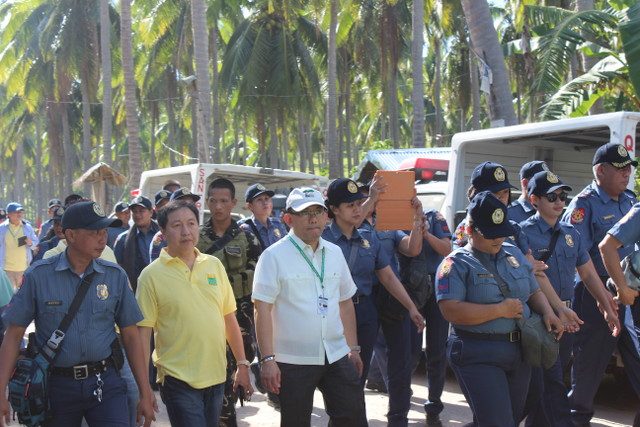 FUTILE PLAN. DAR Undersecretary for Legal Affairs Luis Pangulayan (in white) and police personnel accompany farmers during an installation attempt on May 15, 2015 