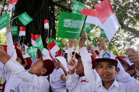 Sejumlah siswa Sekolah Dasar (SD) memegang bendera untuk menyambut kedatangan Raja Salman di sekitar Istana Bogor, Kota Bogor, Jawa Barat, Rabu (1/3). Foto oleh Yulius Satria Wijaya/ANTARA 