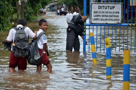 Dua pelajar SD menerobos banjir usai pulang sekolah di Perumahan Bukit Cengkeh 2, Depok, Jawa Barat, Selasa (21/2). Foto oleh Indrianto Eko Suwarso/ANTARA 