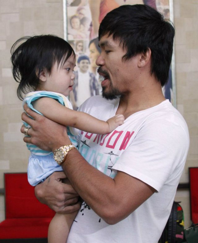 Manny Pacquiao holds his son Israel during training at the Pacman Wild Card Gym on Saturday. Photo by STR/AFP  