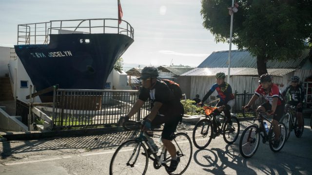 REMEMBER YOLANDA. Cyclists pass by the M/V Jocelyn ship wreck on their way to the iconic San Juanico Bridge where they were converged with the rowing team to send a message to the world: “Unite against climate change and never let anything like Haiyan happen again.” Photo by Francesco Pistilli/Greenpeace 