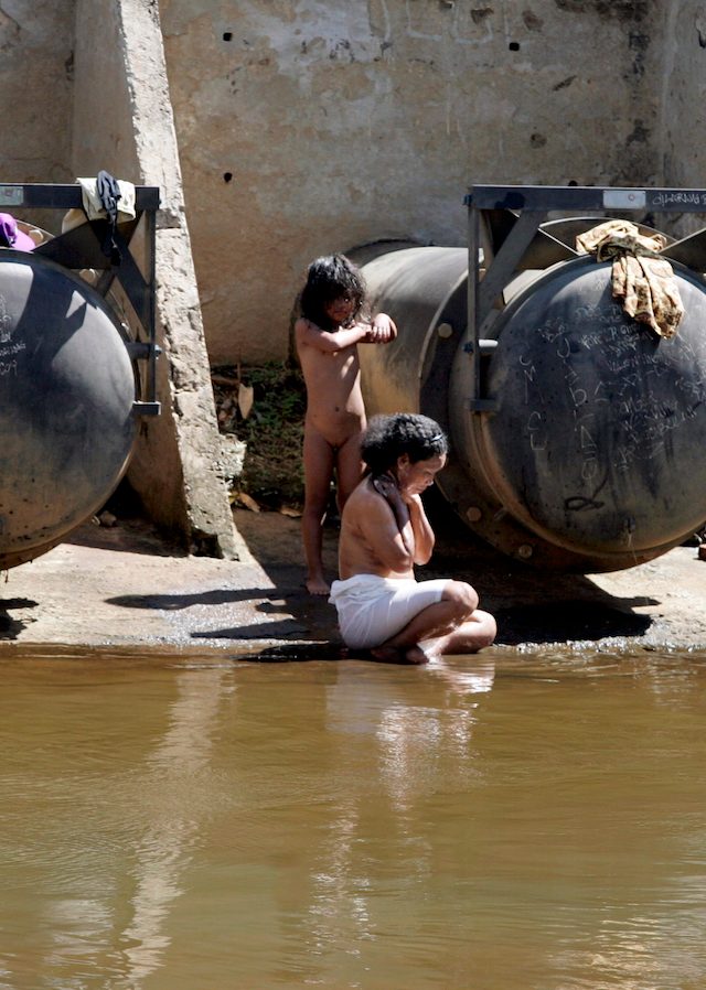 Seorang ibu dan anak perempuannya mandi di depan hidran air limbah di sungai di Jakarta, Maret 2007. Foto oleh Jurnasyanto Sukarno/EPA 