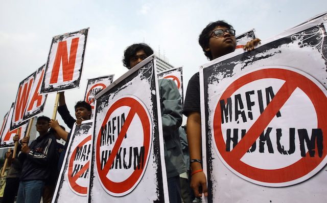 Beberapa pelajar sedang memegang poster bertuliskan "Mafia Hukum" saat menggelar protes anti mafia di Jakarta, 19 November 2009. Foto oleh Bagus Indahono/EPA 