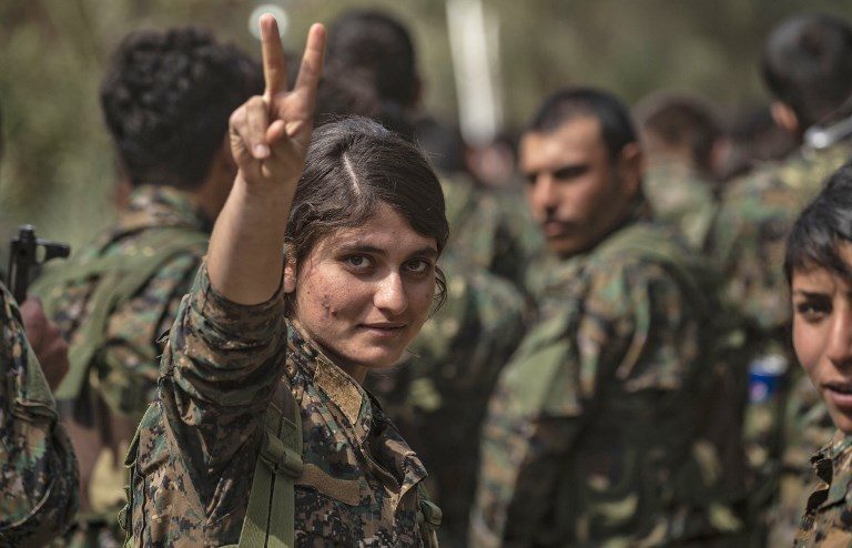 FIGHTER. A female fighter of the US-backed Kurdish-led Syrian Democratic Forces (SDF) flashes the victory gesture while celebrating near the Omar oil field in the eastern Syrian Deir Ezzor province on March 23, 2019. Photo by Delil Souleiman/AFP 