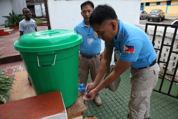 KEEPING CLEAN. United Nations peacekeepers from the Philippines wash their hands to avoid contact with the deadly Ebola virus before entering a service at the Providence Baptist Church in Monrovia, Liberia, 03 August 2014. Ahmed Jallanzo/EPA