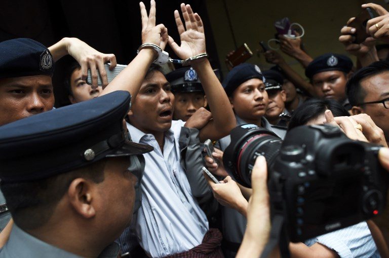 JAILED. Myanmar journalist Kyaw Soe Oo (in cuffs) is escorted by police after being sentenced by a court to jail in Yangon on September 3, 2018. File Photo by Ye Aung Thu/AFP   