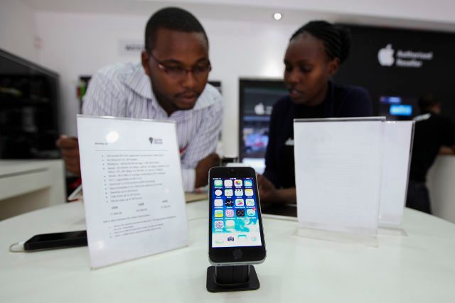 APPLE'S NEXT BIG THING. Kenyan consumers look at an iPhone 5 on display at an Apple authorized dealer shop in Nairobi, Kenya, 03 June 2014. Daniel Irungu/EPA
