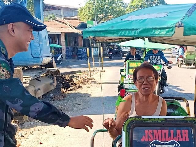EVEN THE ELDERLY. An elderly woman smiles after being given a rose at a checkpoint. PNP-ARMM photo  