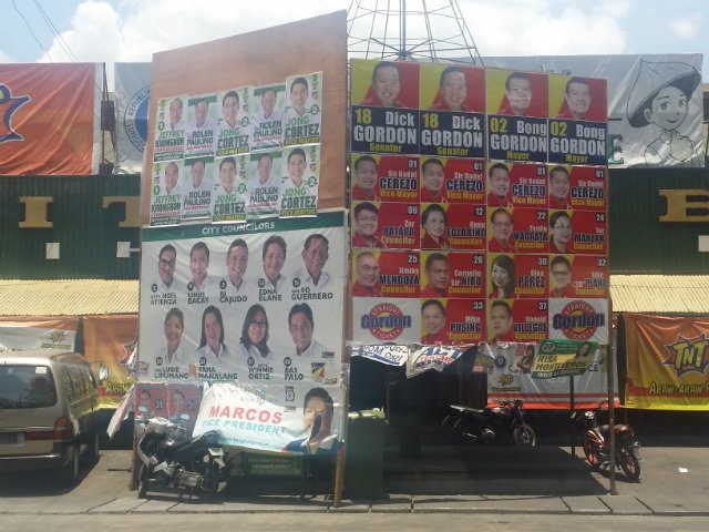 HEATED BATTLE. Posters carrying the names and faces of the ticket headed by former Olongapo Mayor James "Bong" Gordon, seen alongside the posters of Team Paulino ticket candidates. Photo by Reginald Gregg Ceballos 