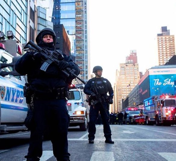 BERSIAGA. Dua polisi bersenjata bersiaga tak jauh dari lokasi ledakan bom tidak jauh dari Times Square, New York, Amerika Serikat, Senin pagi, 11 Desember. Foto oleh Drew Angerer/AFP 