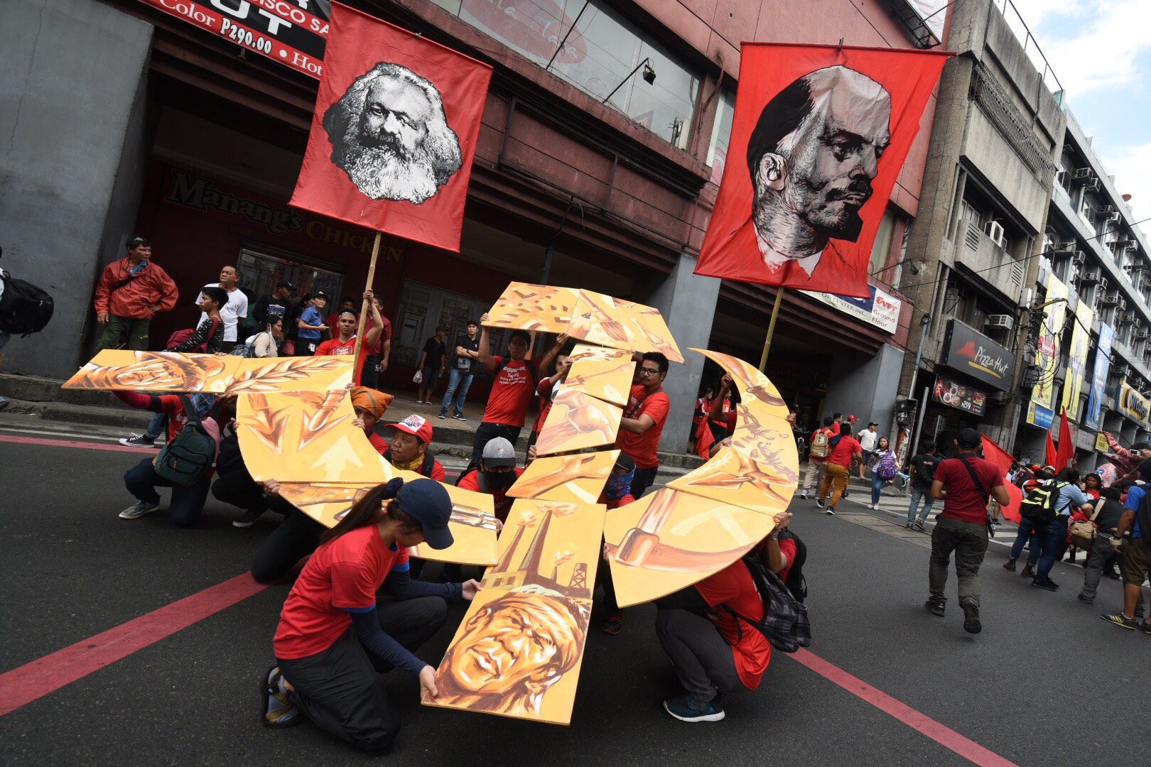 ICONS. Flags with the faces of Karl Marx and Vladimir Lenin and a stylized hammer and sickle showing faces of the Filipino marginalized are being positioned by protesters. Photo by Alecs Ongcal/Rappler   