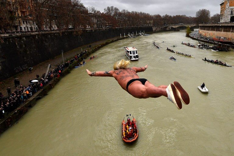 TRADITION. Giuseppe Palmulli aka Mister OK of Italy, dives into the Tiber river as part of traditional New Year celebrations in Rome on January 1, 2018. Photo by Alberto Pizzoli/AFP   