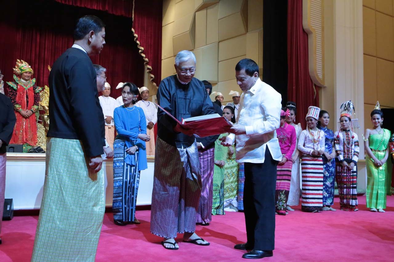 GIFT-GIVING. President Duterte skims through the token presented by Myanmar President U Htin Kyaw during the State Banquet at the Presidential Palace 