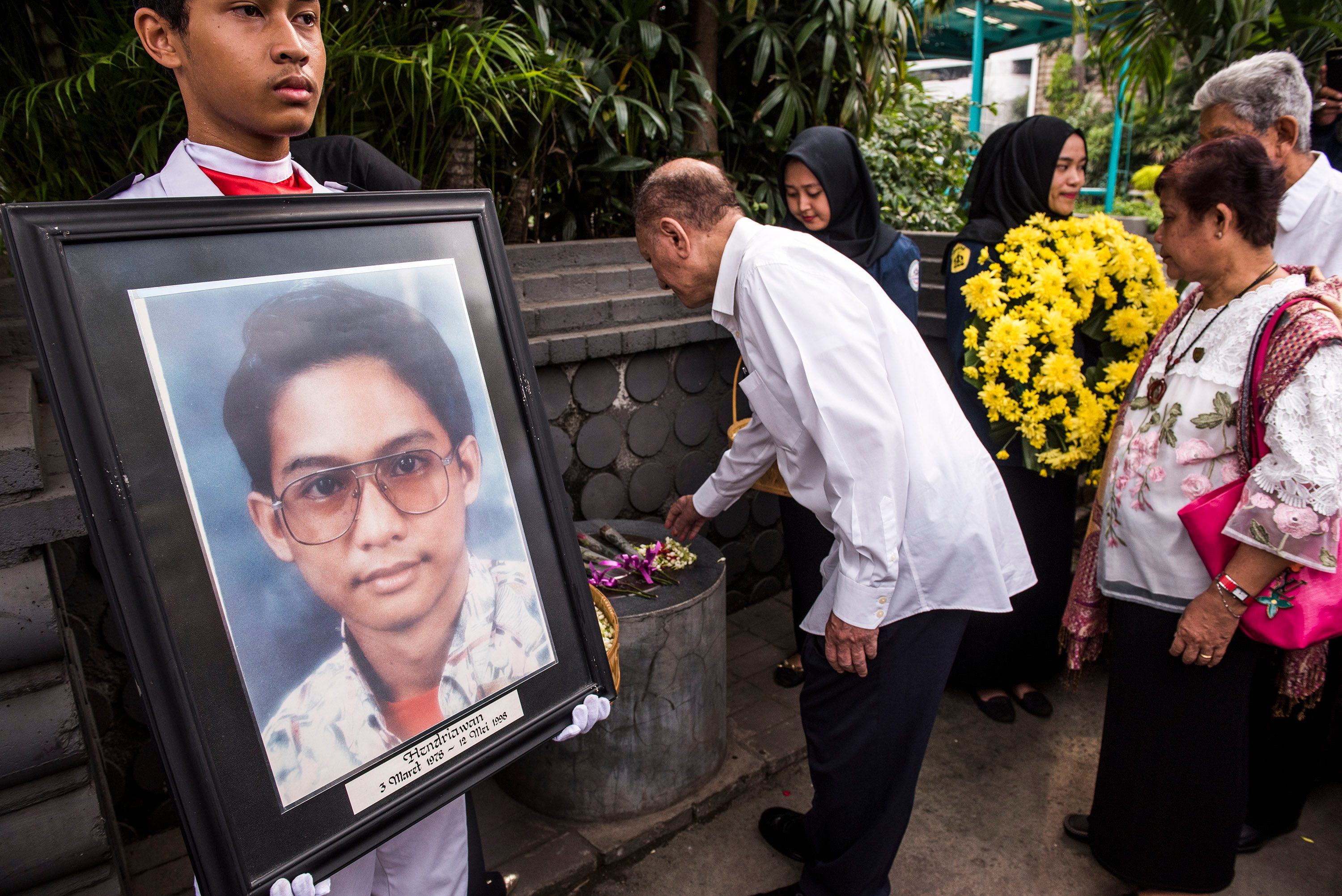 Rektor Universitas Trisakti Thoby Mutis (kedua kiri) menabur bunga di prasasti saat Peringatan 18 Tahun Tragedi 12 Mei 1998 di Universitas Trisakti, Grogol, Jakarta, pada 12 Mei 2016. 