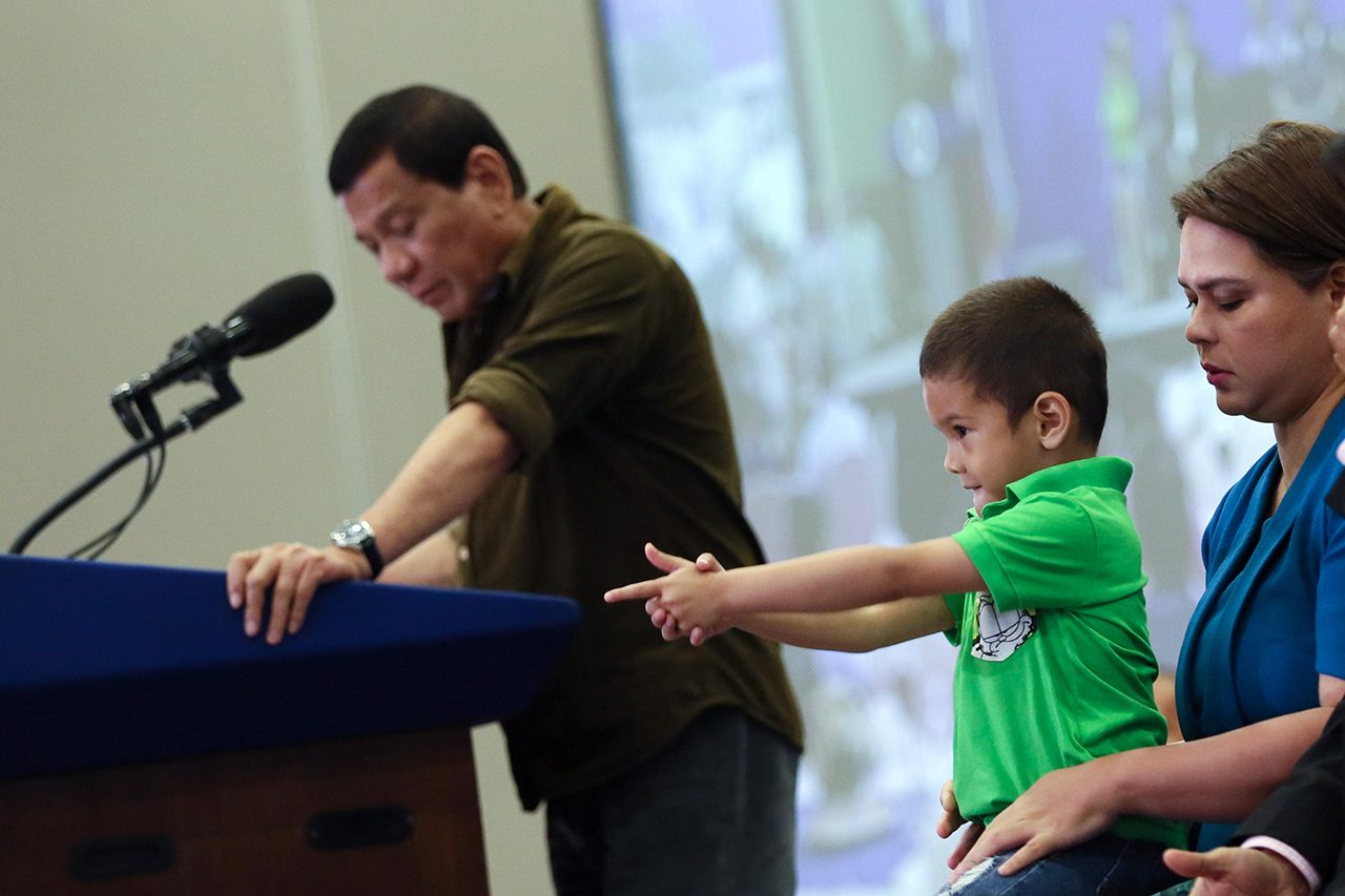 GUN SHOW. Davao City Mayor Sarah Duterte's son gestures as his grandfather speaks in the background during the AFAD Show at the SMX Convention in Lanang, Davao City on May 19, 2017. The show aims to promote security, self-defense, responsible gun ownership and the shooting sport. Malacañang photo  
