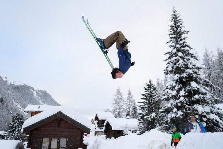 SHORT CUT. Teenager Luc makes a backflip on skis in the small resort of Zinal on January 9, 2018, after heavy snowfall cut off many villages and resorts across the Alps, trapping some 13,000 tourists at Zermatt, one of Switzerland's most popular ski stations. Photo by Fabrice Coffrini/AFP   