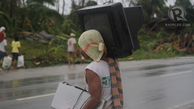 WASHED AWAY. A villager tries to keep his KTV dry and safe from "Pablo". Photo by Karlos Manlupig