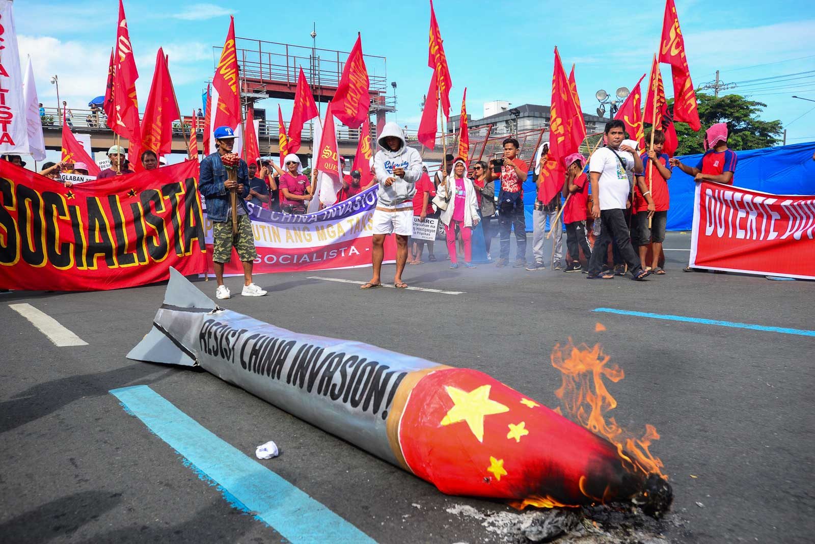 RESISTANCE. Protesters belonging to the group Socialista burns a replica of a Chinese warhead as they stage a picket on Commonwealth Avenue near the Batasan where President Rodrigo Duterte is scheduled to deliver his fourth SONA. Photo by Maria Tan/Rappler 