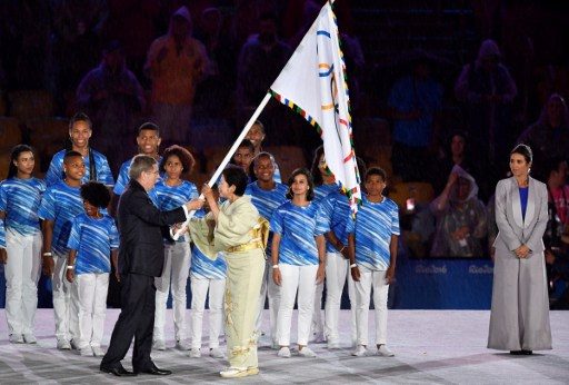 Presiden Komite Olimpiade Internasional Thomas Bach menyerahkan bendera Olimpiade kepada Gubernur Tokyo Yuriko Koike. Foto oleh Fabrice Coffrini/AFP 