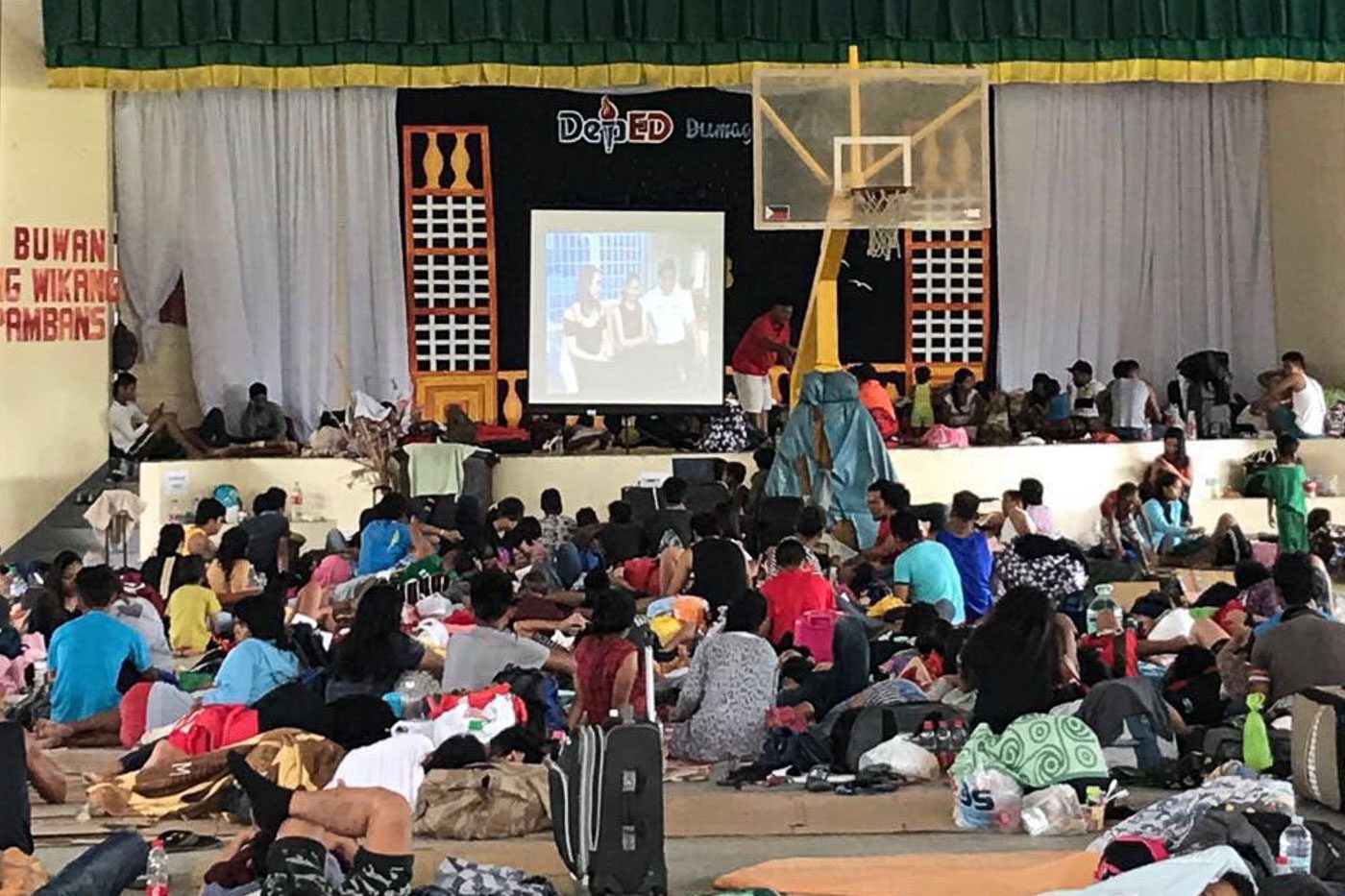 STRANDED. People at the Dumaguete City Evacuation Center watch a movie during the onslaught  of Typhoon Ompong. Photo by Jay Santiago/PPA  