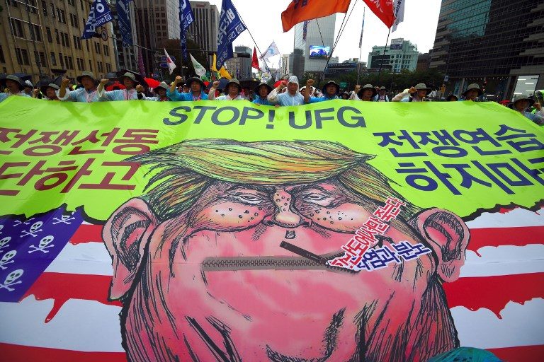 SOKOR RALLY. Protesters in Seoul carry a banner showing a caricature of US President Donald Trump as they march towards the US embassy at an anti-US rally demanding peace in the Korean Peninsula on August 15, 2017. Photo by Jung Yeon-Je/AFP   