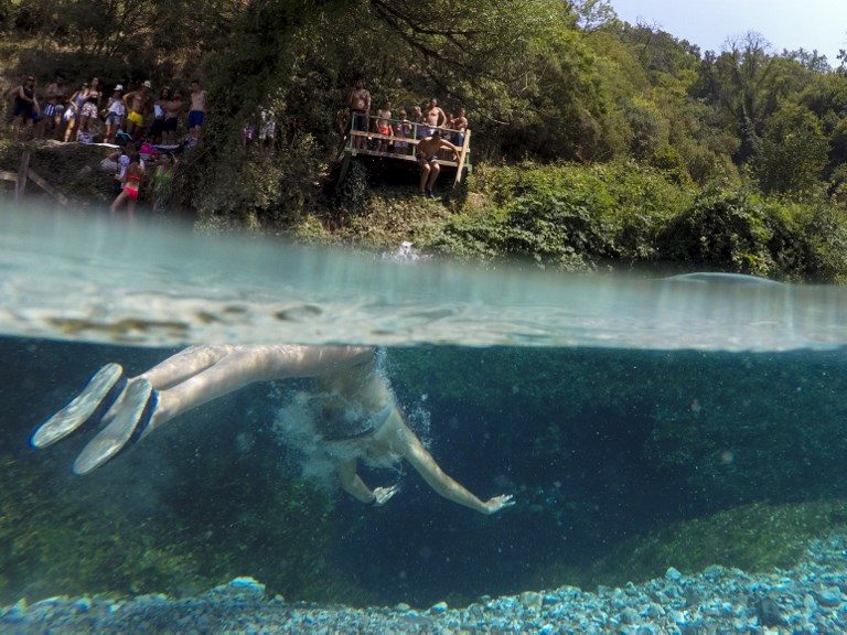 BEATING THE HEAT. A man swims to cool off in the Blue Eye water spring and natural phenomenon near the city of Sarande in Albania, on August 16, 2017. Photo by Gent Shkullaku/AFP   