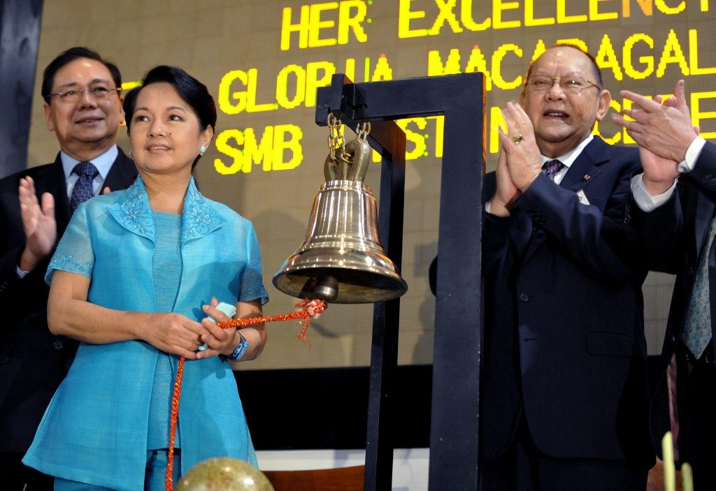 THRIVING BUSINESS. Then-president Gloria Macapagal Arroyo (L) rings the opening bell as San Miguel Corporation chairman Eduardo Cojuangco Jr (R) applauds at the Philippine Stock Exchange on May 12, 2008. Photo by Jay Directo/AFP 