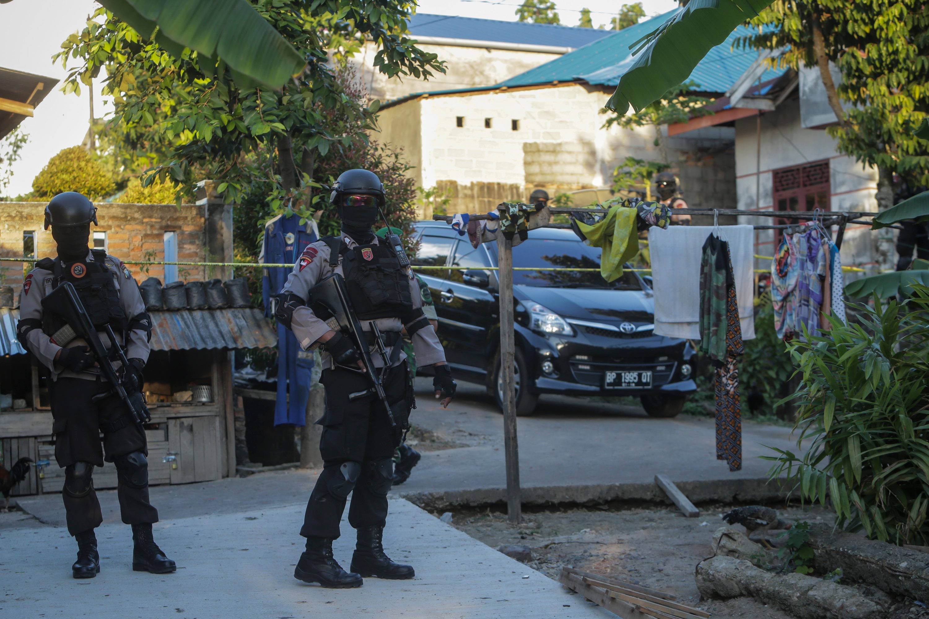 Anggota polisi bersenjata lengkap berjaga di jalan menuju rumah terduga teroris saat dilakukan penggeledahan oleh Tim Densus 88 Anti Teror Polri di Batam, Kepulauan Riau, pada 21 Desember 2016. Foto oleh M N Kanwa/Antara 