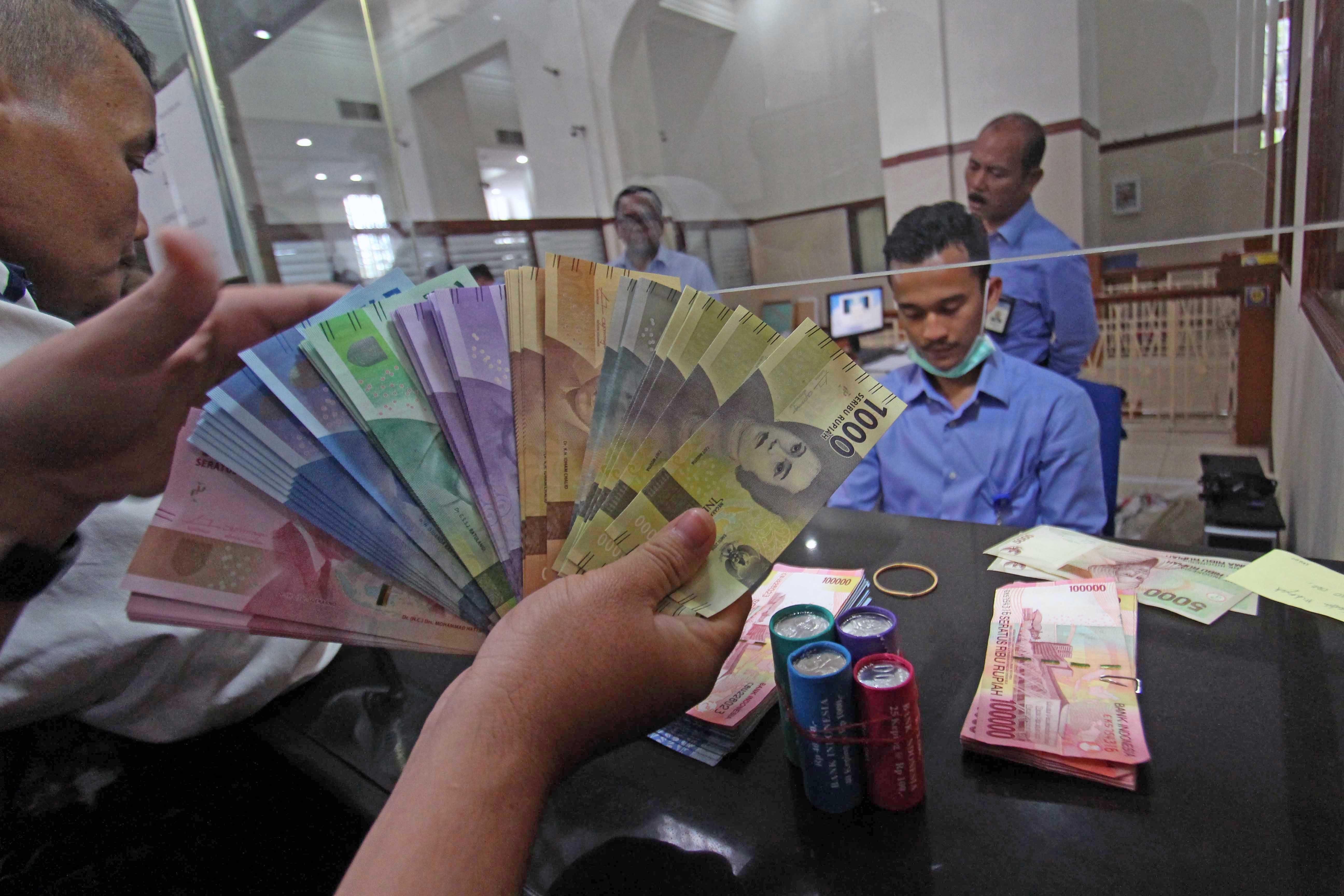RUPIAH. Petugas Bank Indonesia melayani warga untuk menukarkan uang rupiah baru usai diluncurkan di kantor Bank Indonesia Medan, Sumatera Utara, pada 19 Desember 2016. Foto oleh Septianda Perdana/Antara 