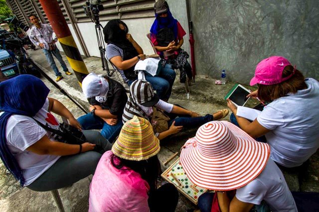 CAREFUL SUPPORT. Iglesia Ni Cristo members converge at 36 Tandang Sora to support Angel and Tenny Manalo on July 26. Some of the members cover their faces to hide their identities and avoid expulsion. Photo by Mark Saludes/Rappler  
