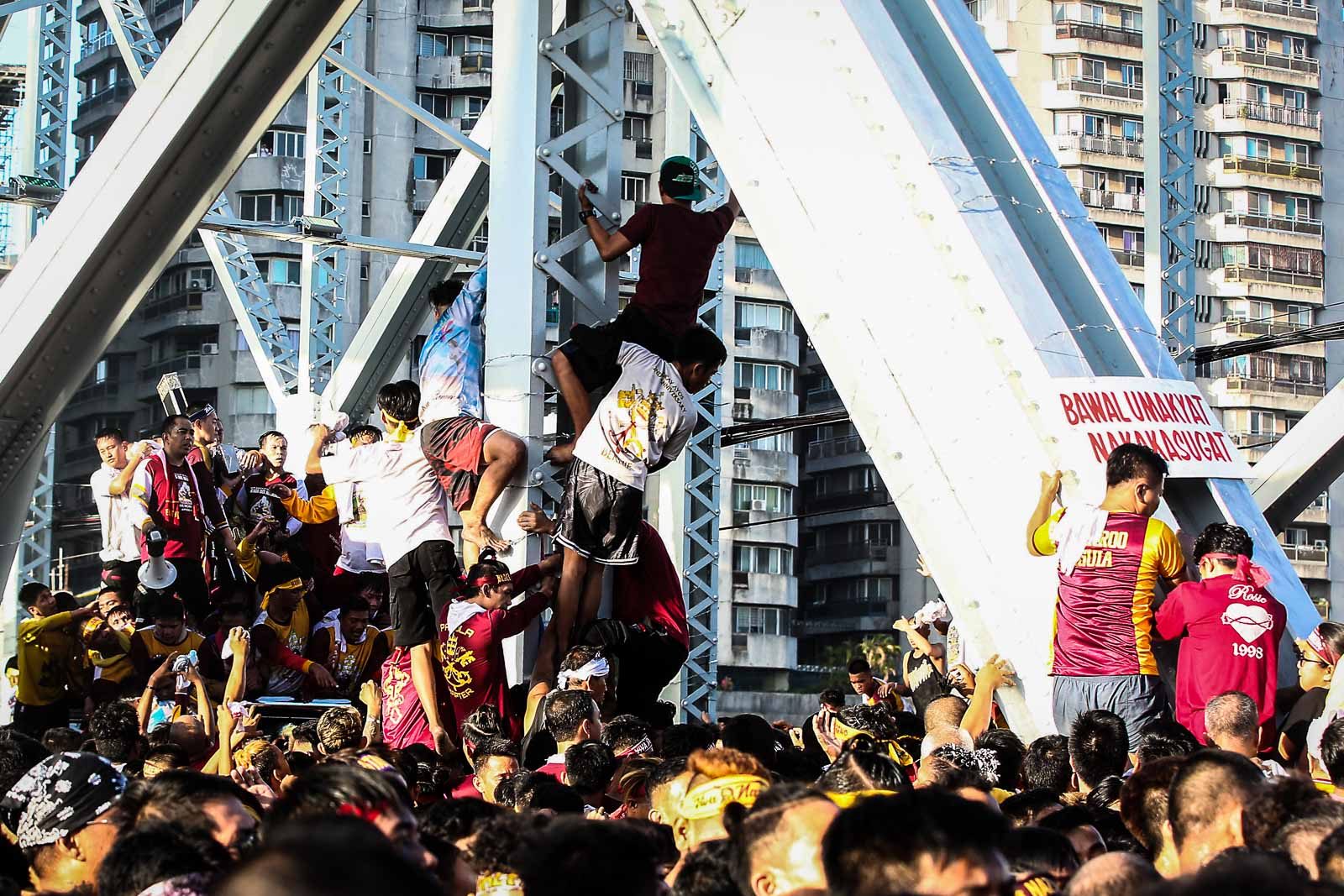 Devotees climb into the Ayala bridge to get a glimpse of the image of the Black Nazarene during the Traslacion on January 9, 2020. Photo by Ben Nabong/Rappler 