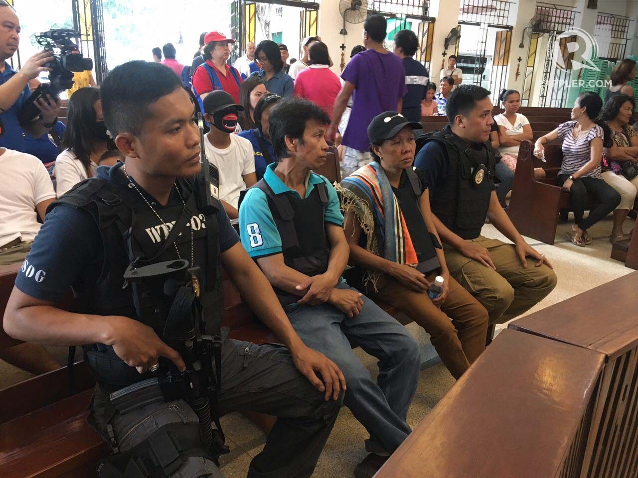 BURIAL MASS. Parents of Kulot de Guzman in San Antonio Abad Parish attend their son's burial mass. They wear protective vests and are surrounded by armed representatives from the DOJ's Witness Protection Program. Photo by Eloisa Lopez/Rappler
 