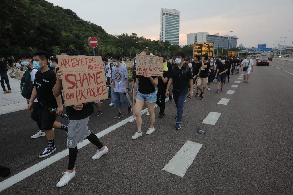 'SHAME ON POLICE.' Protesters walk on a highway near Hong Kong's international airport following a protest against the police brutality and the controversial extradition bill on August 12, 2019. Photo by Vivek Prakash/AFP 