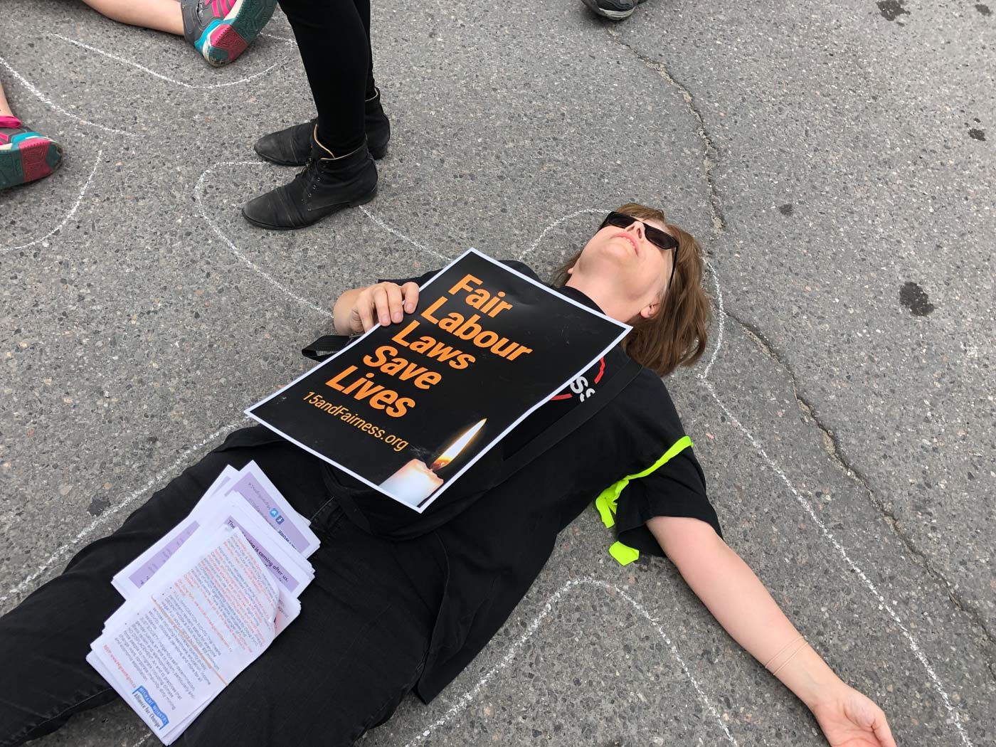 MIGRANT WORK IN CANADA. Protesters stage a 'die-in' to demonstrate the precarious nature of migrant work and the deaths that occur in unsafe job sites. Photo by Marites Sison 
