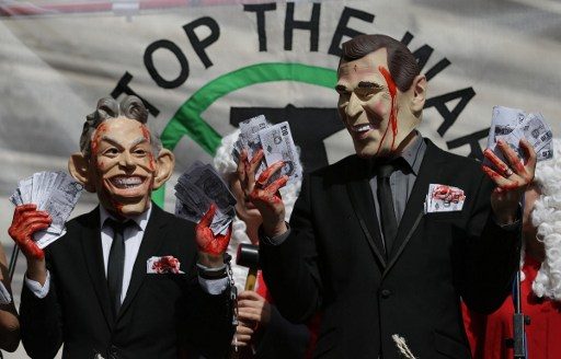 OUTRAGE. Demonstrators wearing masks depicting former British prime minister Tony Blair (L) and former US president George W. Bush protest outside QEII Center in London on July 6, 2016. Photo by Daniel Leal-Olivas/AFP 