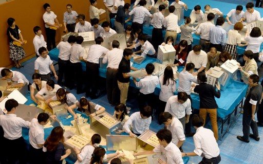 VOTE-COUNTING. Officials of the election administration committee open ballot boxes to count votes cast for Japan's upper house election at an electoral office in Tokyo on July 10, 2016. Photo by Toru Yamanaka/AFP 