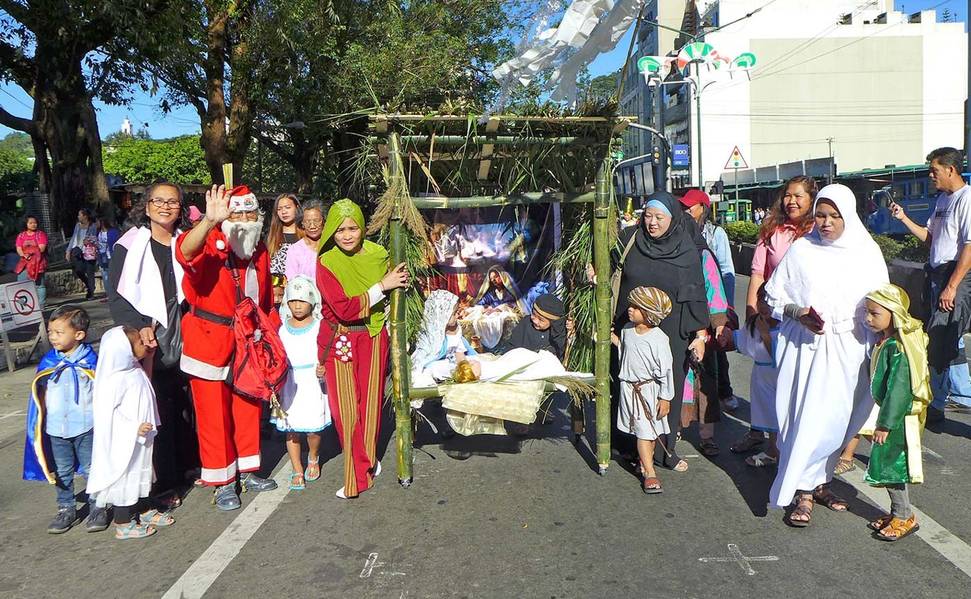 CHRIST IS BORN. The parade also includes kids and parents reenacting the birth of Jesus in a manger 