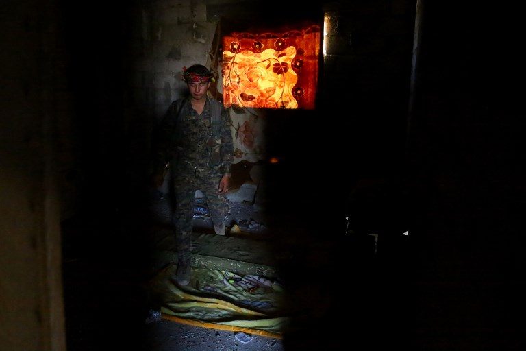 ALLIANCE. A member of the Syrian Democratic Forces (SDF) – an alliance of Kurdish and Arab fighters – is holed inside a room  in the suburb of Dariya on the western city limits of Raqa on on June 27, 2017, after the SDF seized the area from the Islamic State (ISIS) group. Photo by Delil Souleiman/AFP   