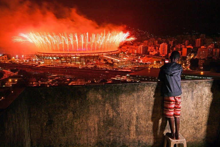 A boy from Mangueira favela watch fireworks over Maracana Stadium during the 2016 Olympics closing ceremony in Rio de Janeiro on August 21, 2016. Carl de Souza/AFP 