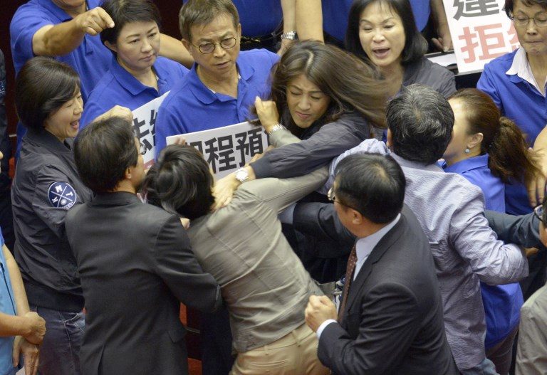 PARLIAMENTARY BRAWL. Taiwan's main opposition Kuomintang (KMT) legislator Hsu Shu-hua (C, facing camera) fights with ruling Democratic Progressive Party (DPP) Chu Yi-ying (front C, in grey) during a review of a major infrastructure project at the Parliament in Taipei on July 13, 2017. Photo by Sam Yeh/AFP   