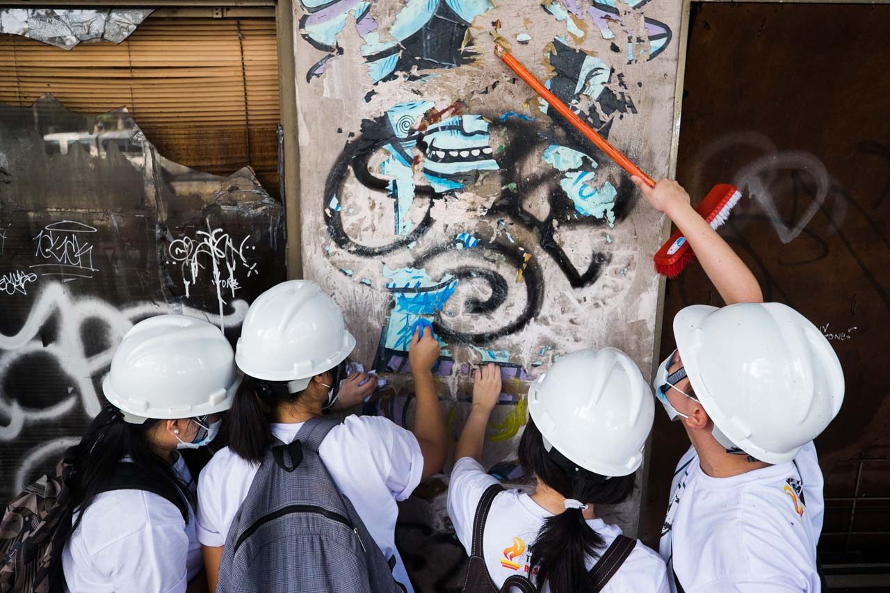 PEELING. Architecture students who volunteered for the clean-up attempt to remove the stickers on the wall of the METon December 12, 2015. The NCCA will continue to involve volunteer students and citizens in the restoration of the landmark.   