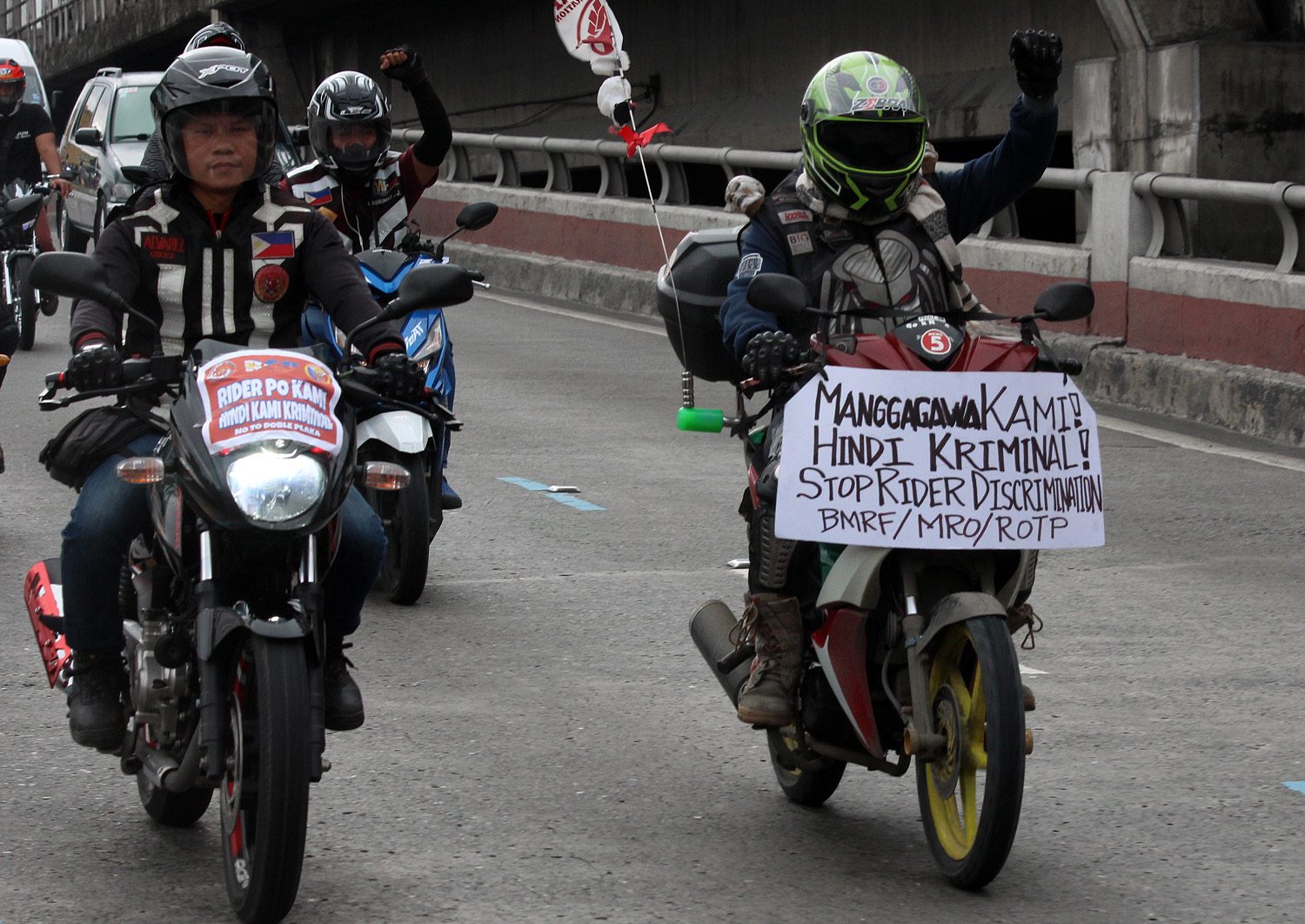 LIVELIHOOD. An Angkas driver displays a placard on his motorcycle that reads 'Manggagawa Kami! Hindi Kriminal! Stop Ride Discrimination.' Photo by Darren Langit/Rappler  