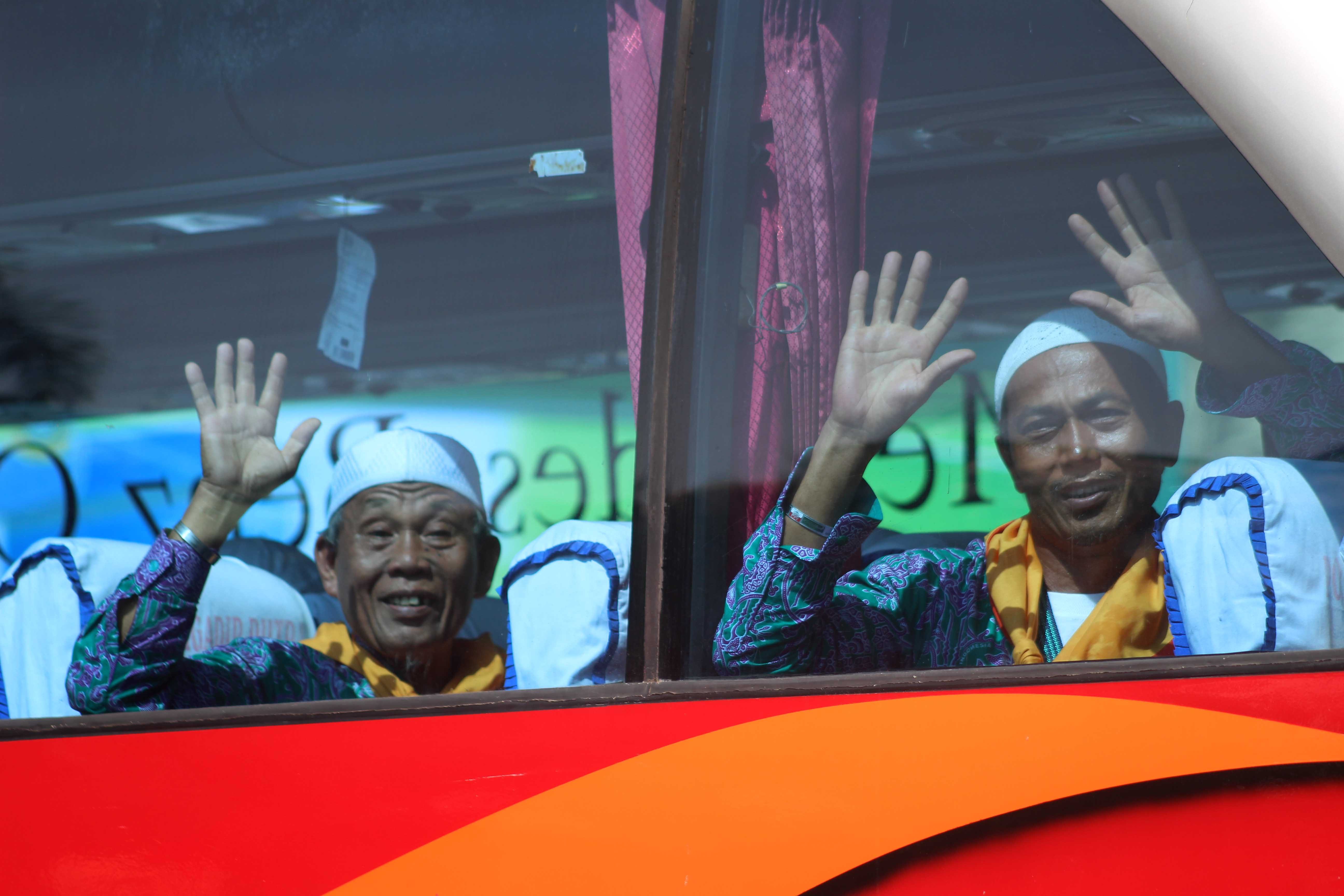 Dua orang calon haji melambaikan tangan kepada keluarga saat diberangkatkan dari Asrama Haji Medan, Sumatera Utara, pada 9 Agustus 2016. Foto oleh Septianda Perdana/Antara 