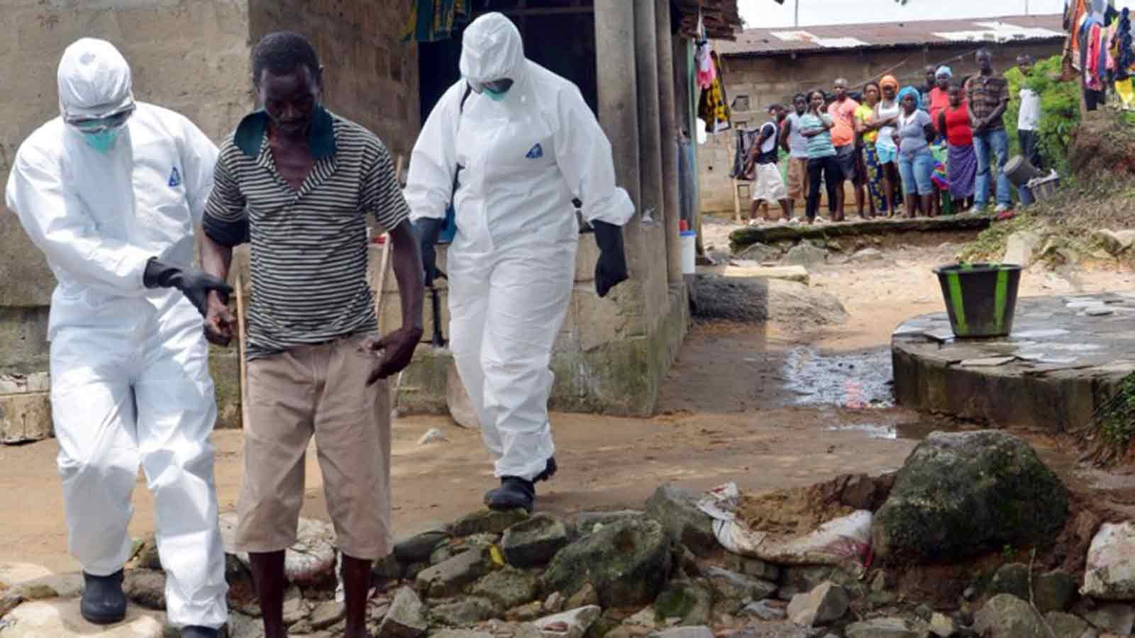 A picture taken on August 25, 2014 in Monrovia shows nurses wearing a protective suit escorting a man infected with the Ebola virus to a hospital in Monrovia. Zoom Dosso/AFP  